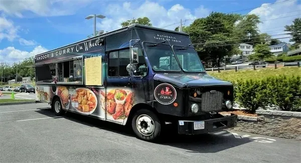 A food truck with many different foods on the side.